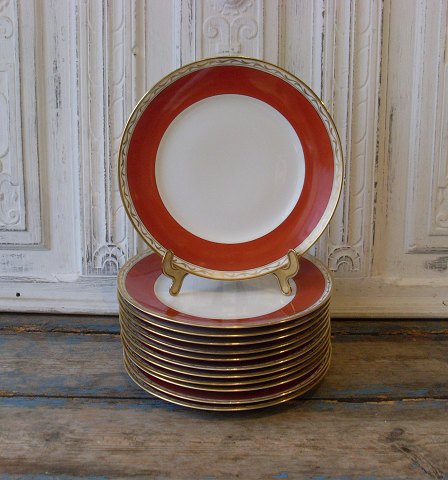 Royal Copenhagen dækketallerkener dekoreret med guld og teglfarvet fane, no. 9785
